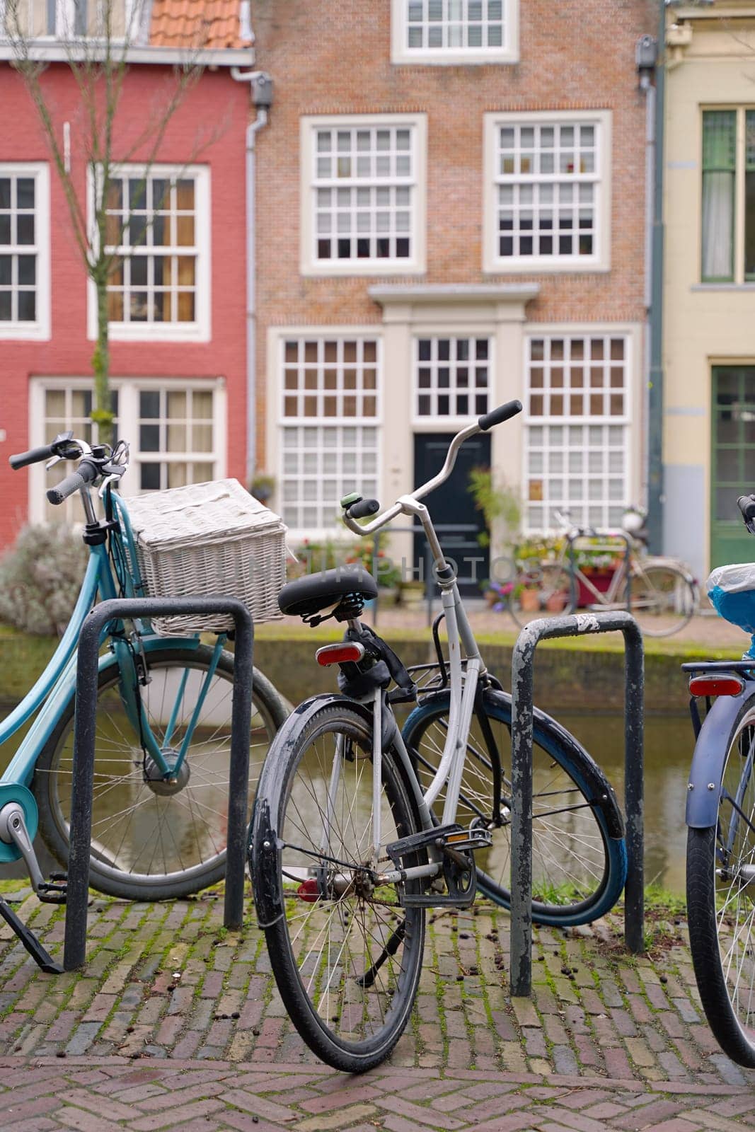 Picturesque Netherlands. Bicycles parked alongside a channel on beautiful old buildings background. by berezko
