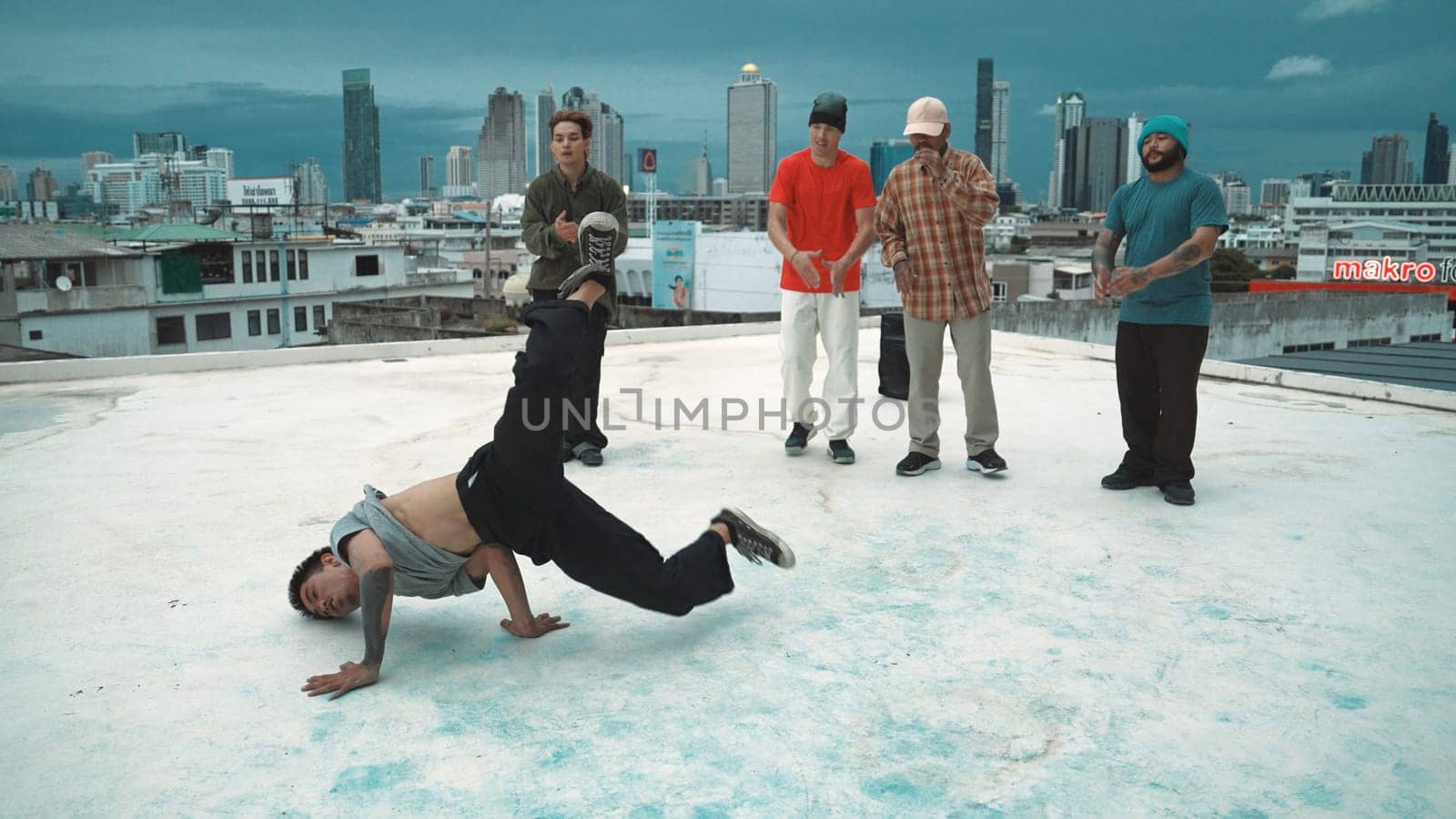 Hispanic hipster dancing surrounded by multicultural friend at city view with blue sky. Group of street dancer performing at rooftop. Active, fun, happy atmosphere. Outdoor sport 2024. Endeavor.
