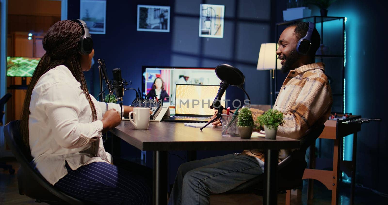 Show host and guest arriving in studio to record podcast with professional equipment. Woman and man fist bumping coming in broadcasting space using quality audio devices for flawless sound