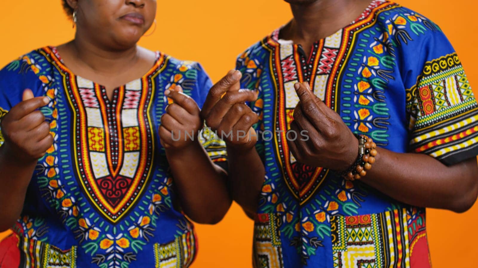 Serious husband and wife asking for salary in studio, rubbing their fingers to ask for cash payment or loan. Ethnic people in poverty demanding money income, financial difficulties. Close up.