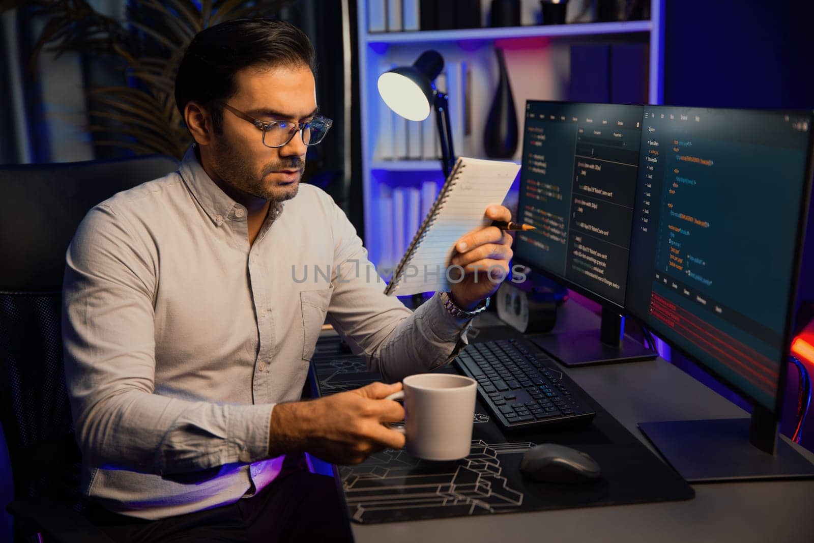 Smart IT developer working with coffee on software development coding on pc screen, reading note with newest application project program update online website data at neon light cyber office. Surmise.