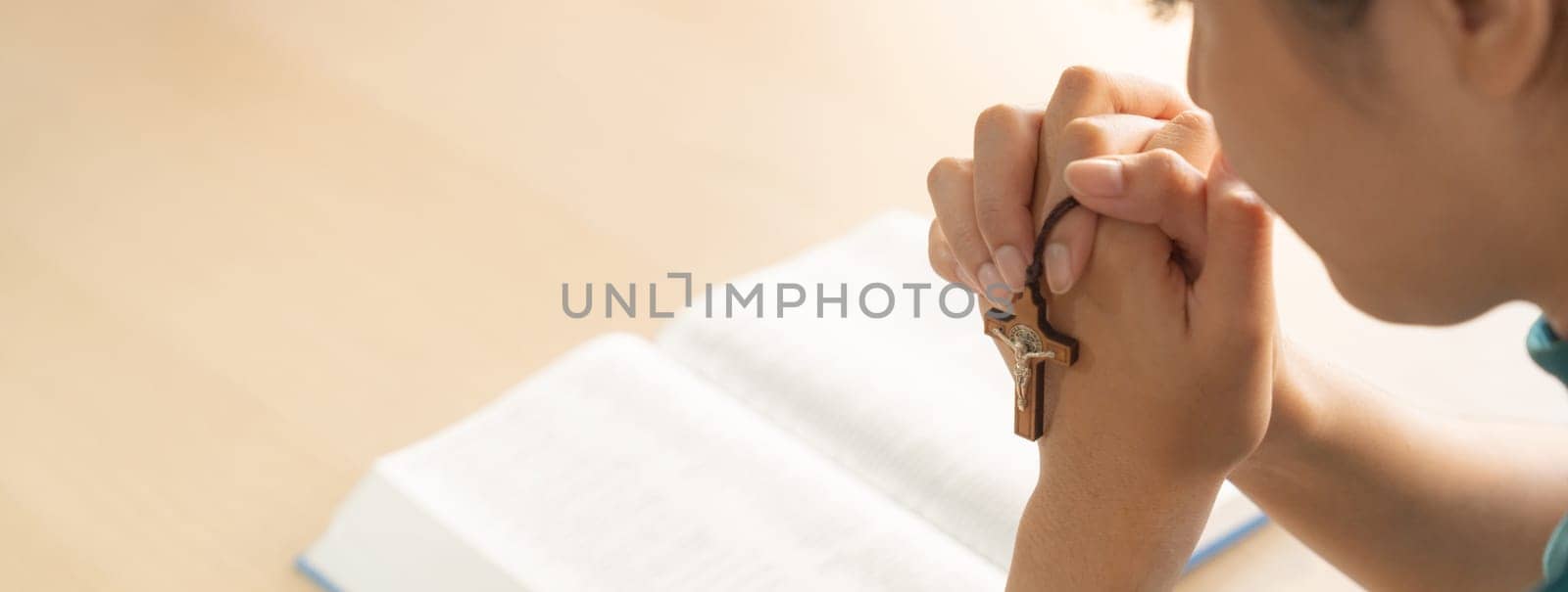 Female folded hand prayed on holy bible book faithfully at wooden church. Concept of hope, religion, faith, christianity, catholic, believe and god blessing. Warm and brown background. Burgeoning.