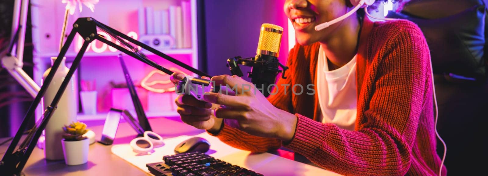 African American girl streamer playing online fighting with Esport skilled team wearing headphones in neon color lighting room. Talking other players planing strategies to win competitors. Tastemaker.