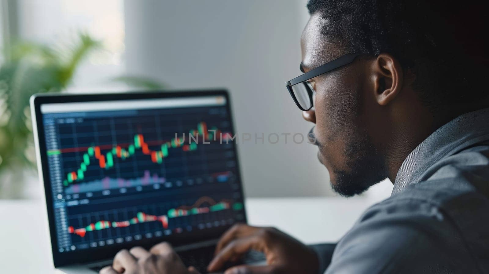 A close up photo of a young investor studying stock options on a laptop.