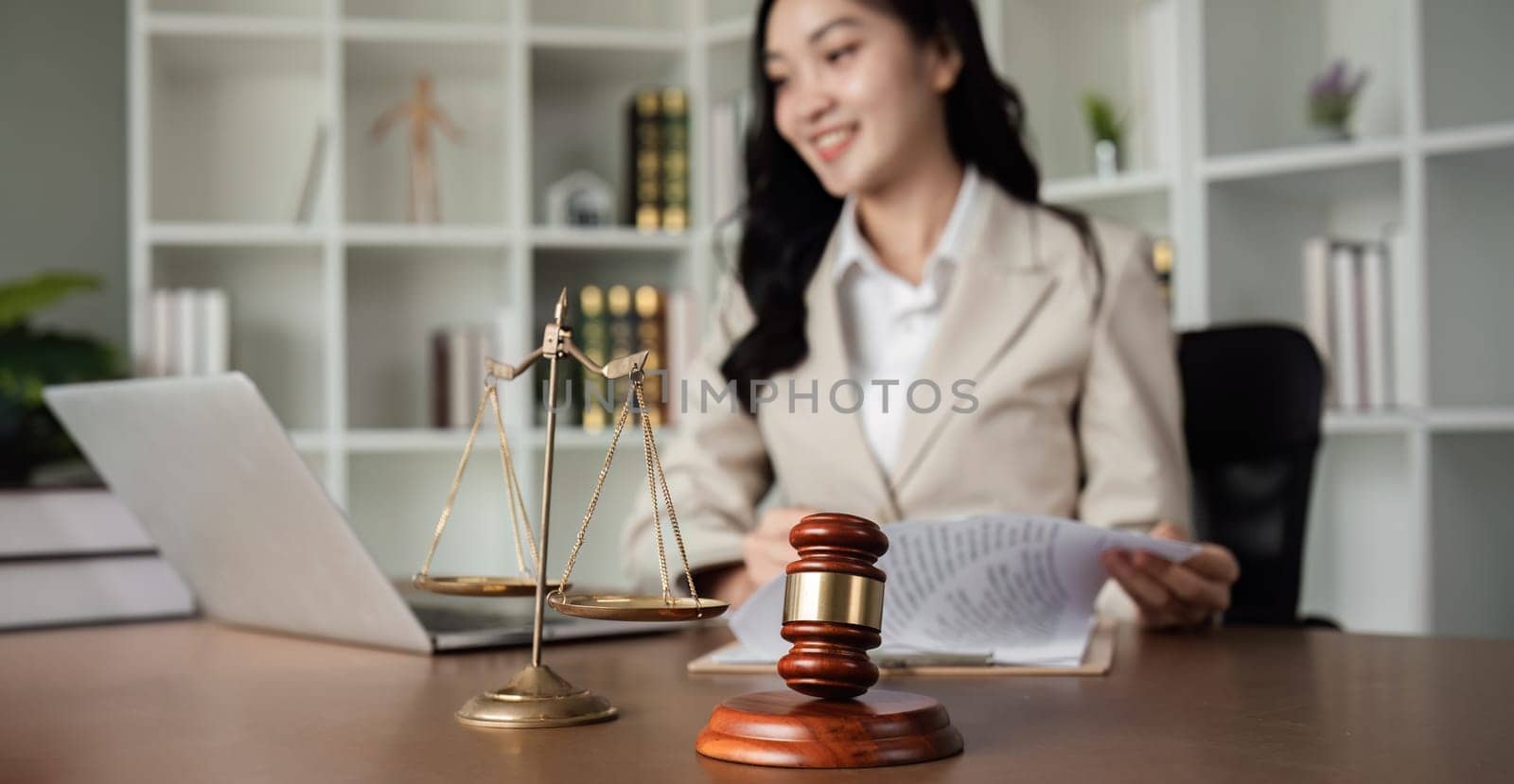 A female Asian lawyer reviews business and real estate laws. Legal consultants provide legal advice and guidance online via laptops in lawyers' offices. by wichayada