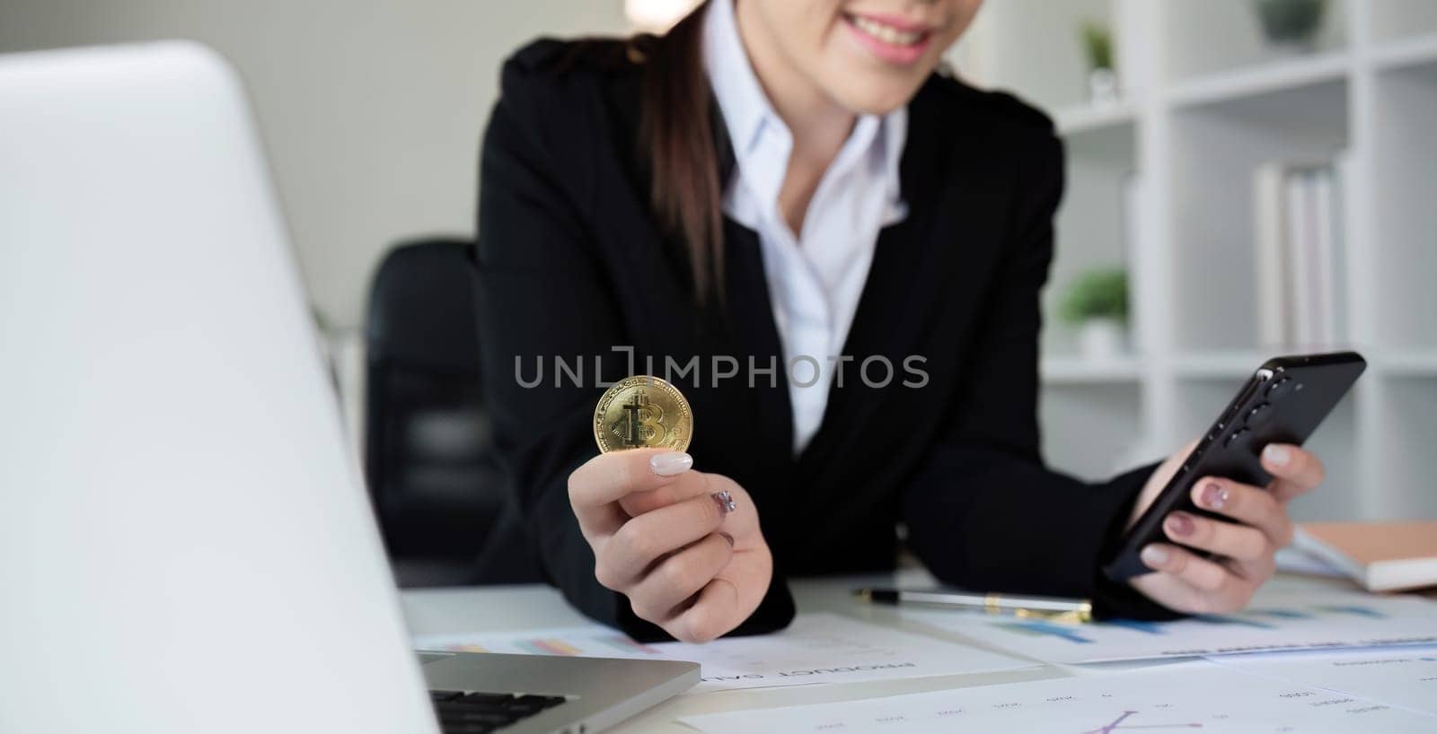 A successful business woman holds the cryptocurrency Bitcoin in her hands. Concept of trading and using digital currencies.