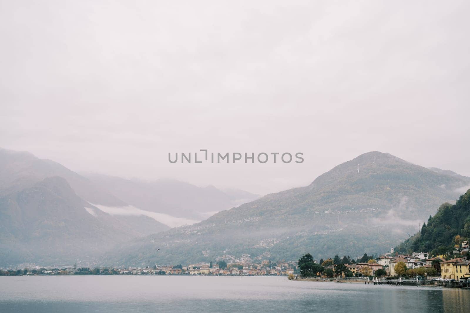 Misty mountains on the coast of Lake Como with luxury villas. Italy by Nadtochiy