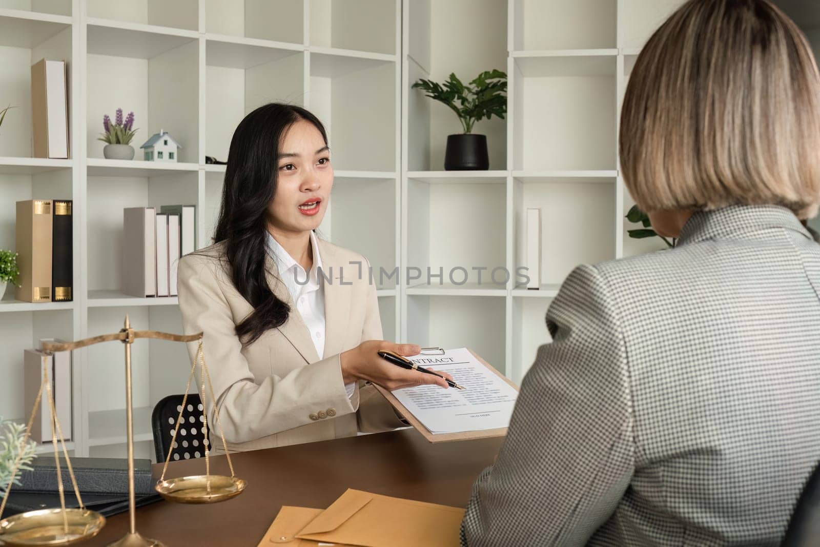 Lawyer and businesswomen discussing and introducing Providing legal advice regarding signing insurance contracts or financial contracts by wichayada