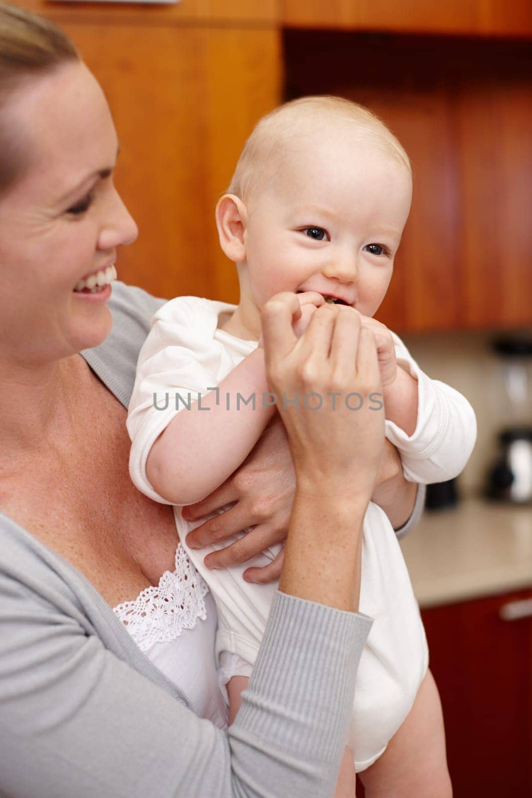 Happy, mother and baby in kitchen for love, child development and bonding at home, house and apartment together. Woman, kid and family with smile for pride, growth and affection with embrace or hug.