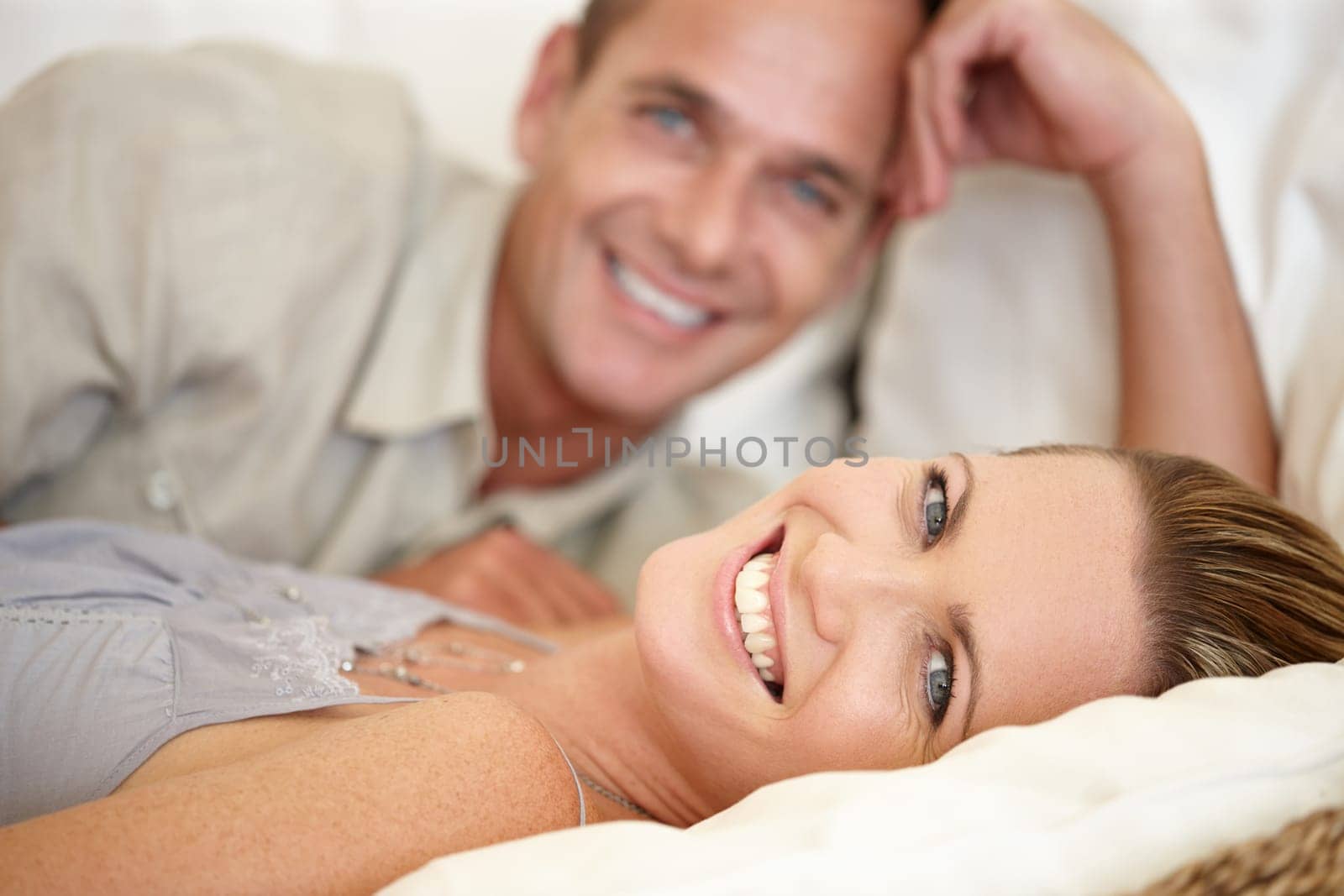 Couple, smile and portrait in bed together, relax and support or hotel for bonding. Happy people, commitment and romance for date in bedroom, peace and affection for connection in relationship by YuriArcurs