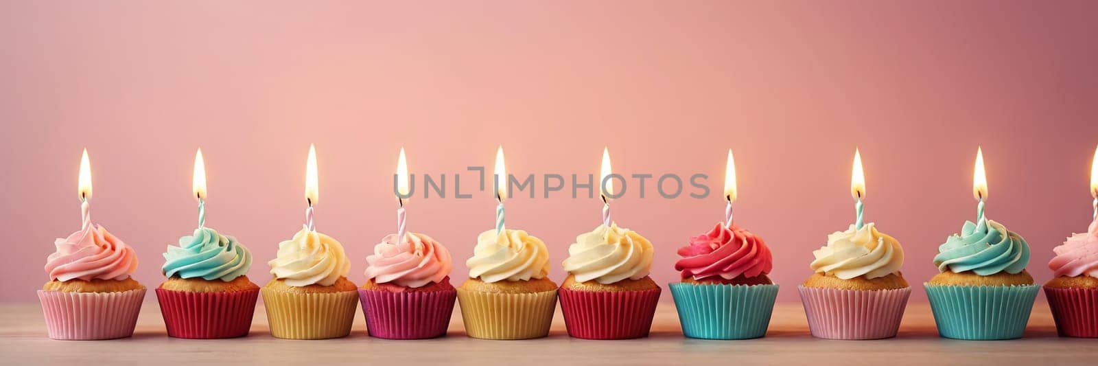 Colorful cupcakes with lit candles are displayed against a pink background, indicating an indoor celebration event marking of joy and celebrating. with free space by Matiunina