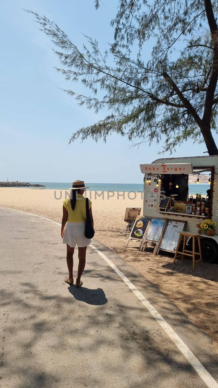 A stylish man walking down a bustling street lined with food carts, enjoying the sights and smells of street food vendors by fokkebok