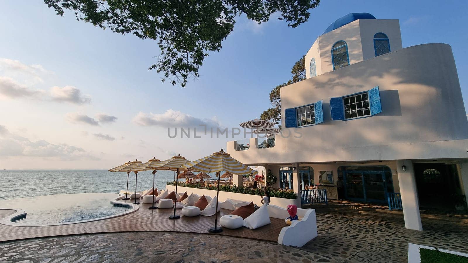 Bangsaray Pattaya Thailand 28 February 2024, A majestic white building with a shimmering pool, surrounded by colorful umbrellas creating a tranquil oasis in the bustling city.
