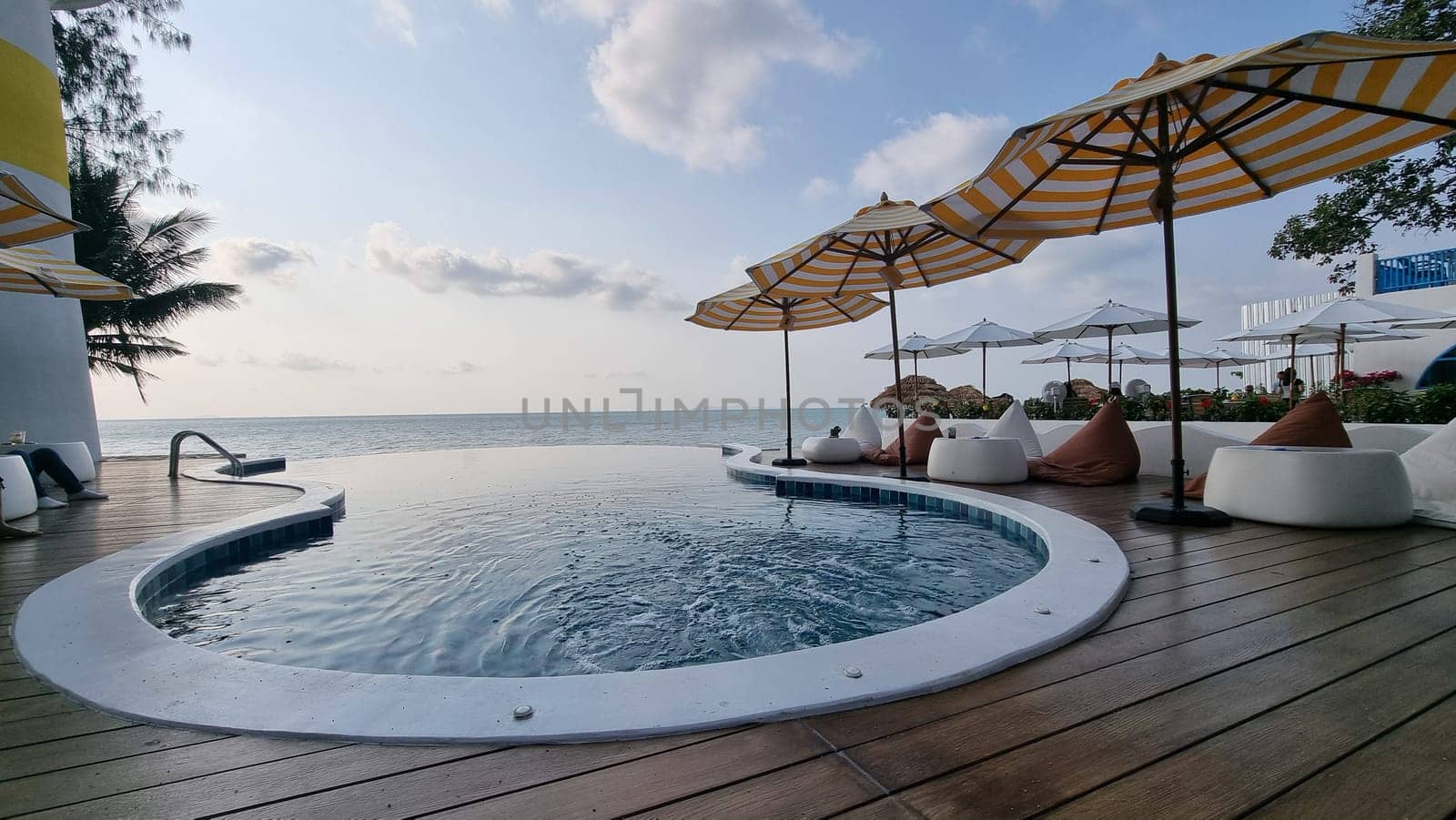 Bangsaray Pattaya Thailand 28 February 2024, A sparkling, large swimming pool surrounded by colorful umbrellas and inviting chairs, creating a peaceful and relaxing environment under the sun.