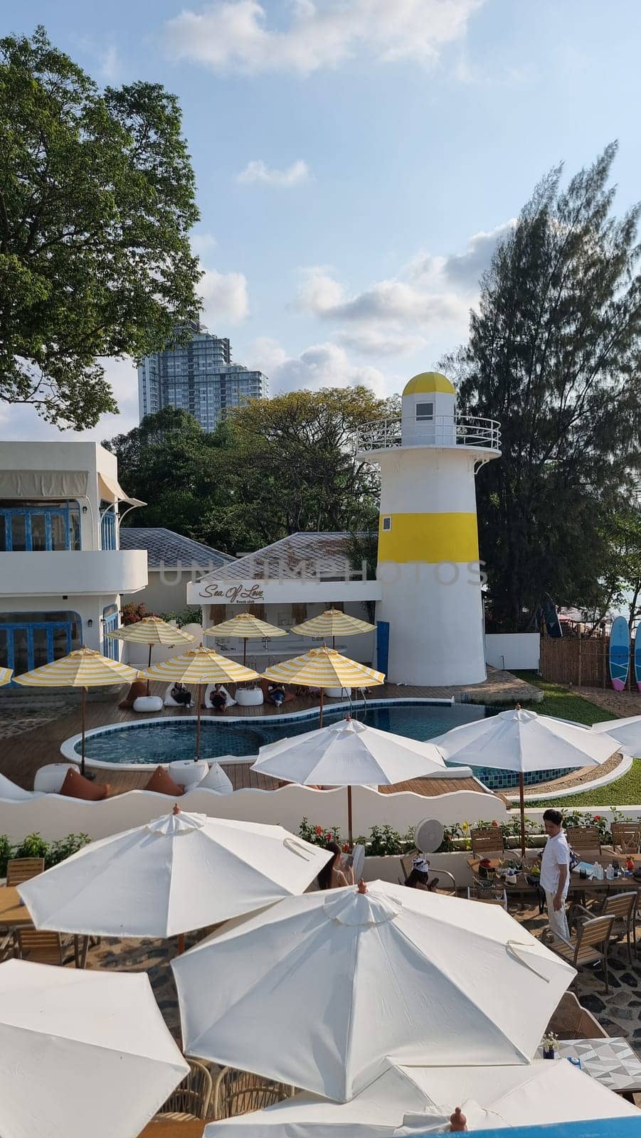 Bangsaray Pattaya Thailand 28 February 2024, Colorful umbrellas providing shade next to a serene swimming pool, creating a vibrant and relaxing atmosphere for leisure and relaxation.