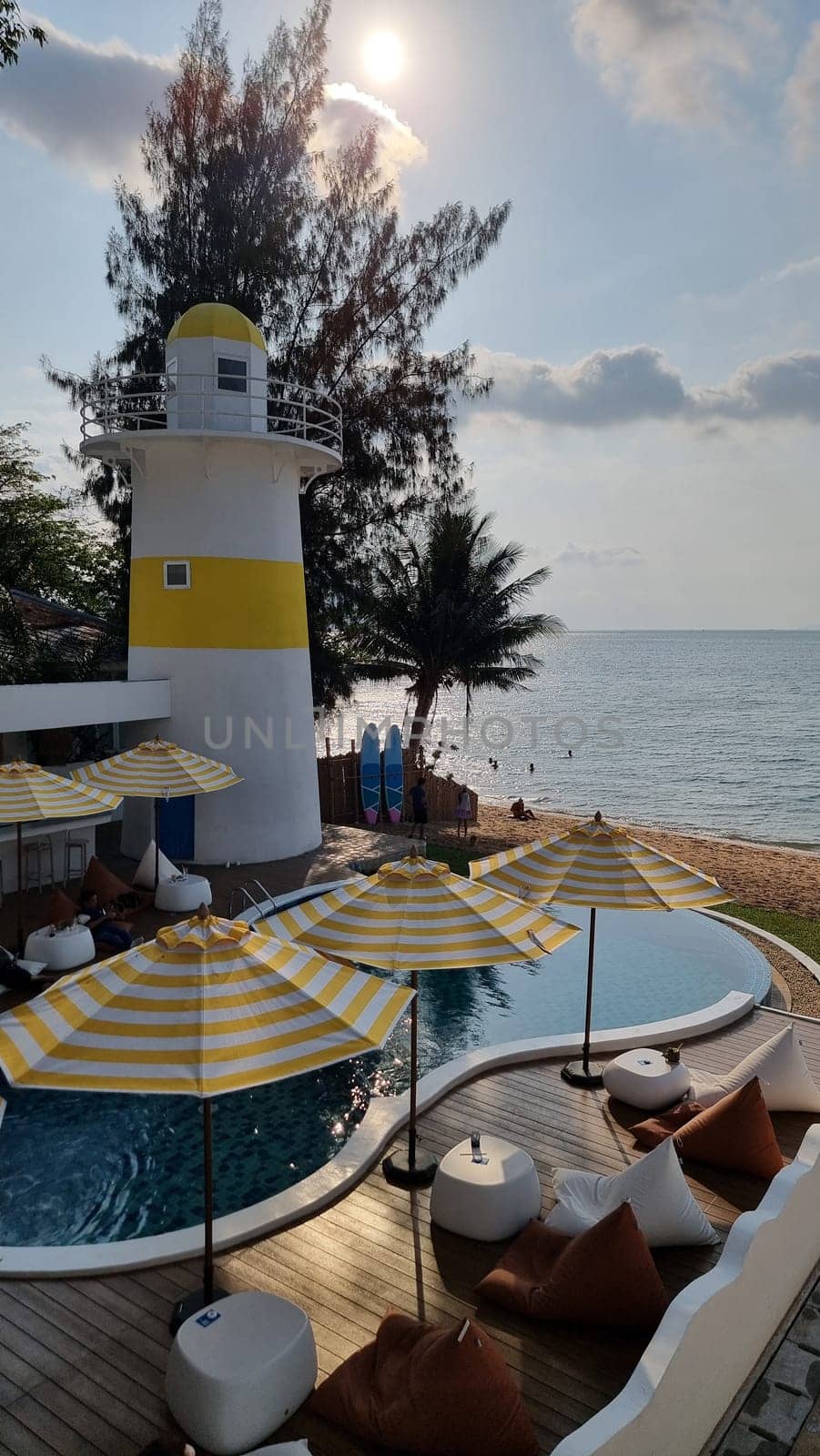 Bangsaray Pattaya Thailand 28 February 2024, Lounge chairs and umbrellas line the deck, offering a relaxing view of the lighthouse against the scenic backdrop.
