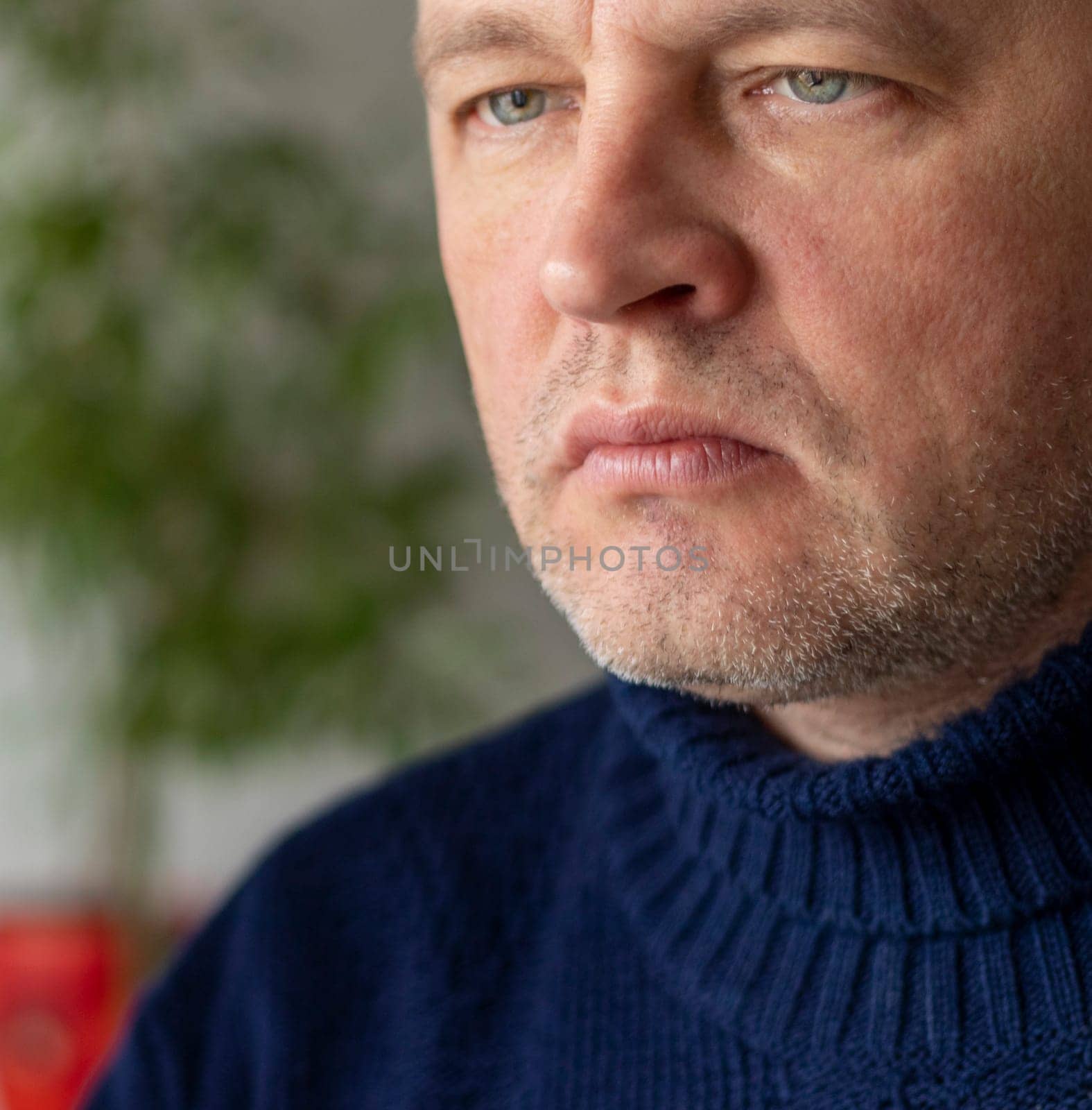 Portrait of the mid aged man with grey hair, wearing warm, dark blue sweater