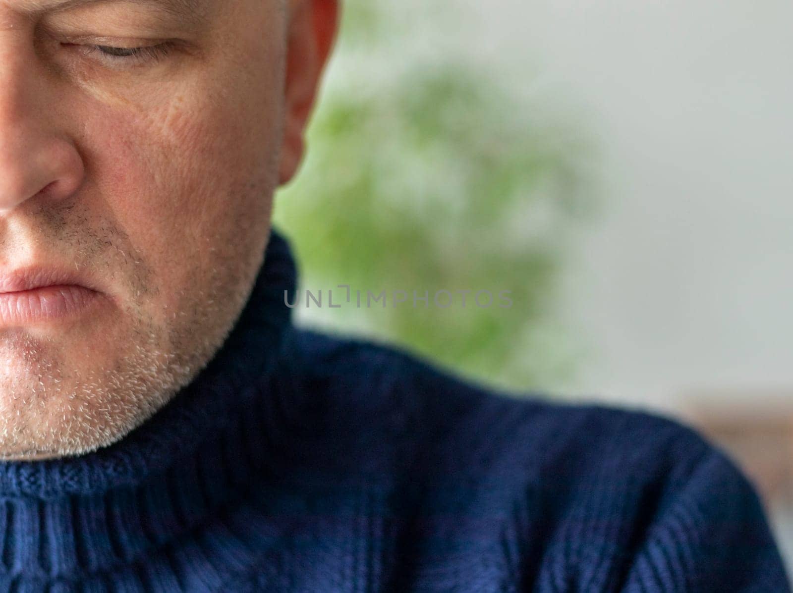 Portrait of the mid aged man with grey hair, wearing warm, dark blue sweater