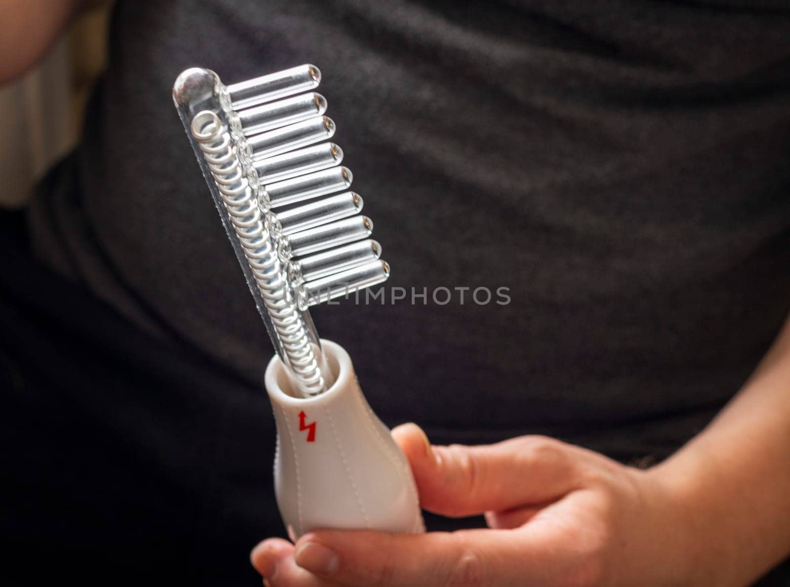 Close up shot of the high frequency comb tool for hair and scalp treatment.