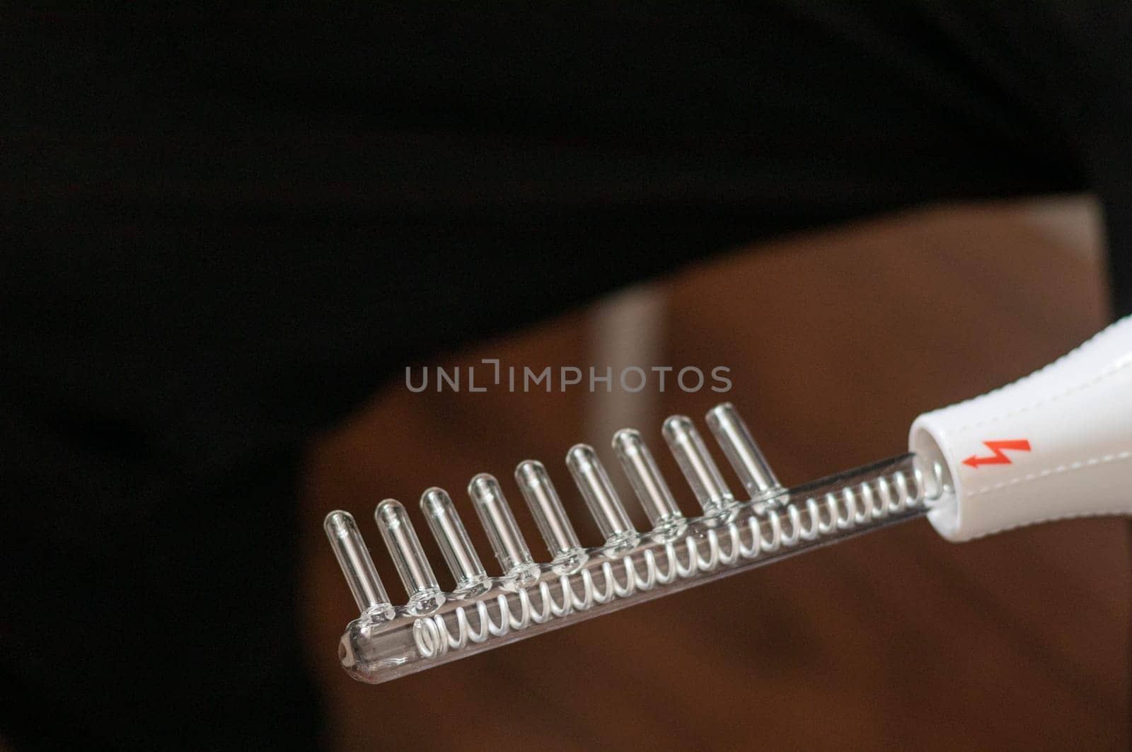 Close up shot of the high frequency comb tool for hair and scalp treatment.