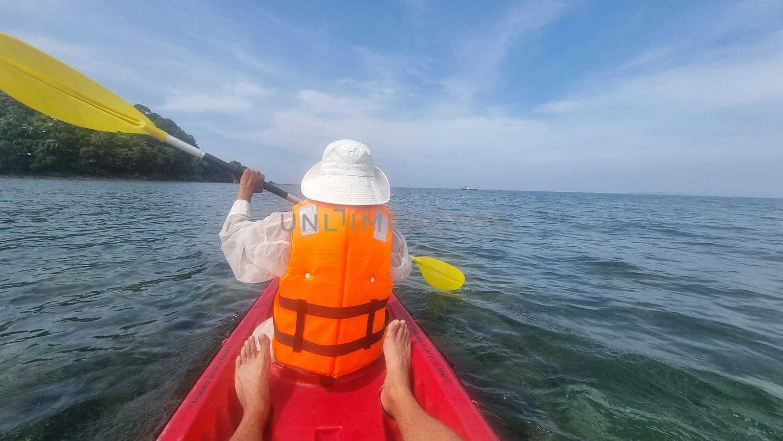 A women person in a kayak gracefully maneuvers through calm waters, surrounded by the beauty of nature. Koh Libong Thailand