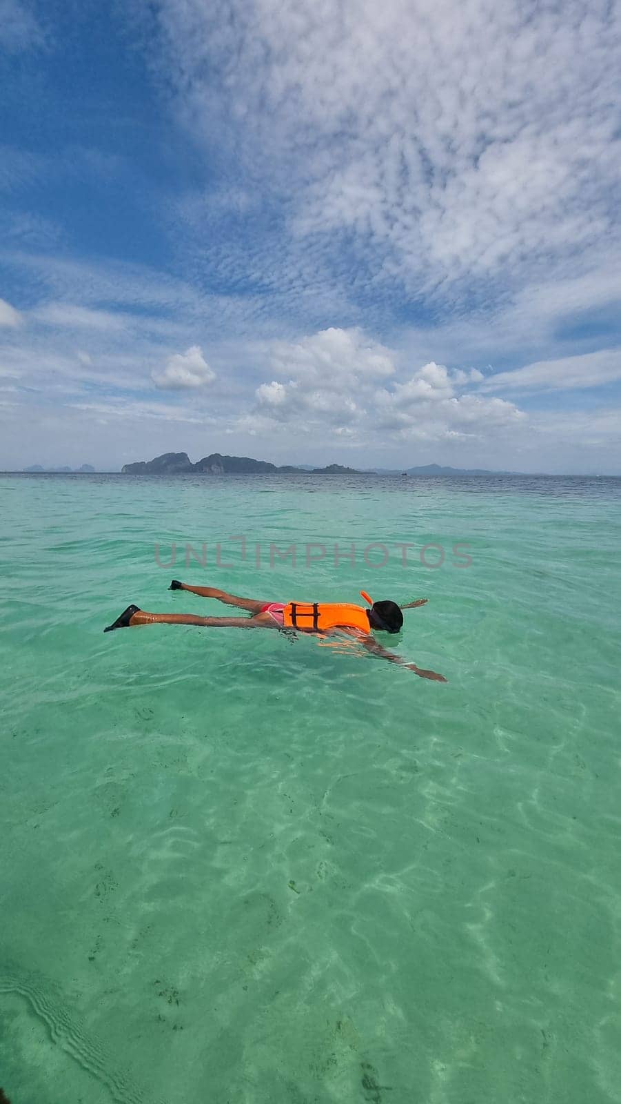 A woman peacefully floats in the ocean on a surfboard, embracing the tranquility of the water beneath her by fokkebok