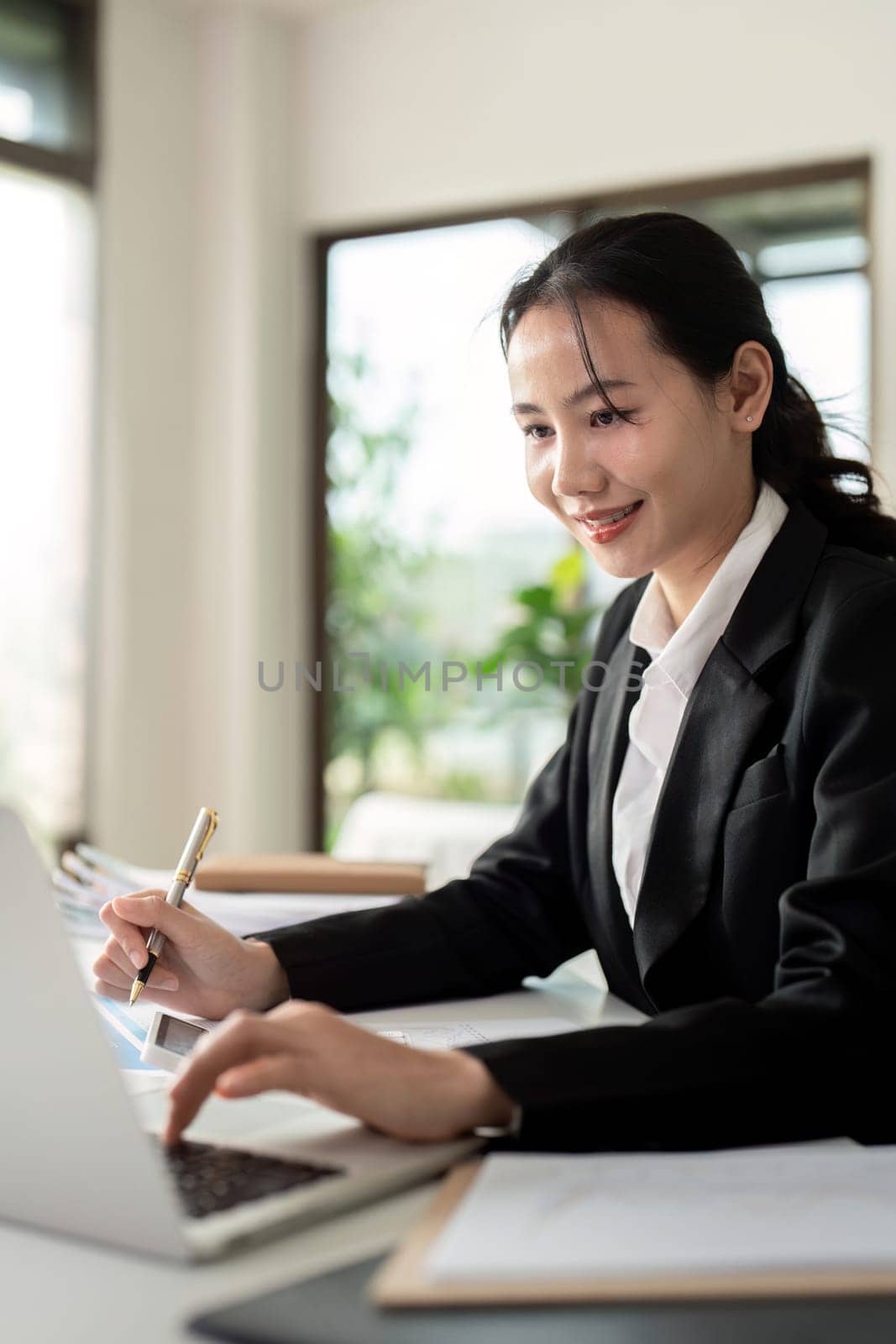 Asian woman accounting sit at their desks and calculate financial graph showing results about their investment, planning successful business growth process by nateemee