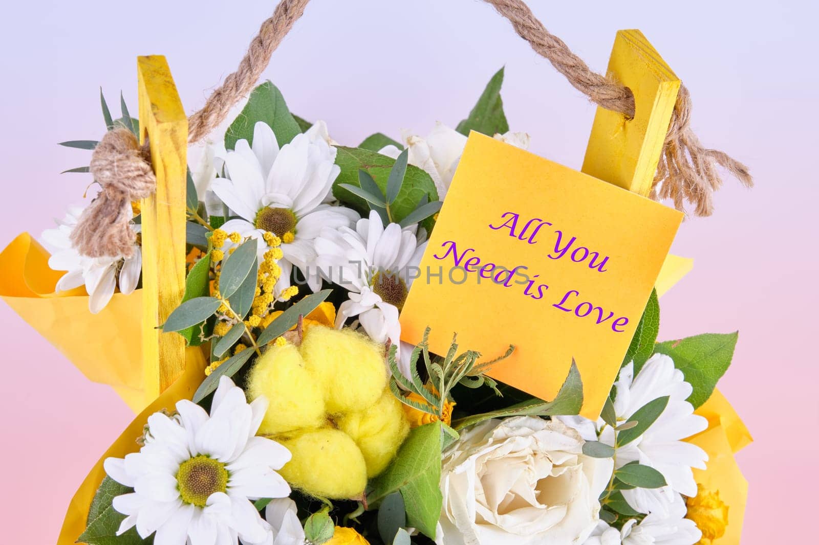 All you need is love slogan written on the sticker on the flowers. Concept photo