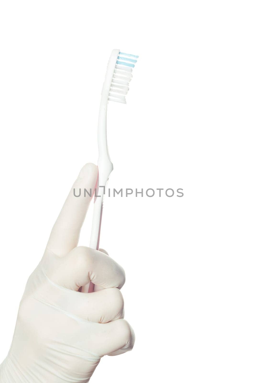 Gloved doctor's hand holding a toothbrush