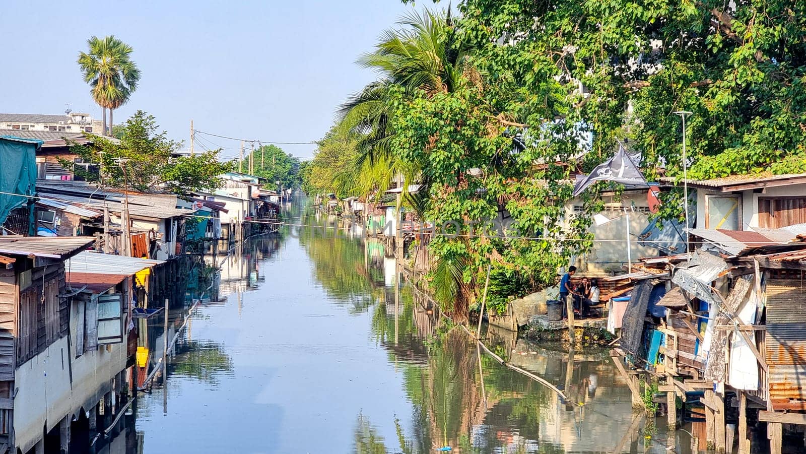 Bangkok Thailand 13 January 2024, A river meanders through a charming village, flanked by houses on either side, creating a picturesque scene of tranquil urban living in harmony with nature.