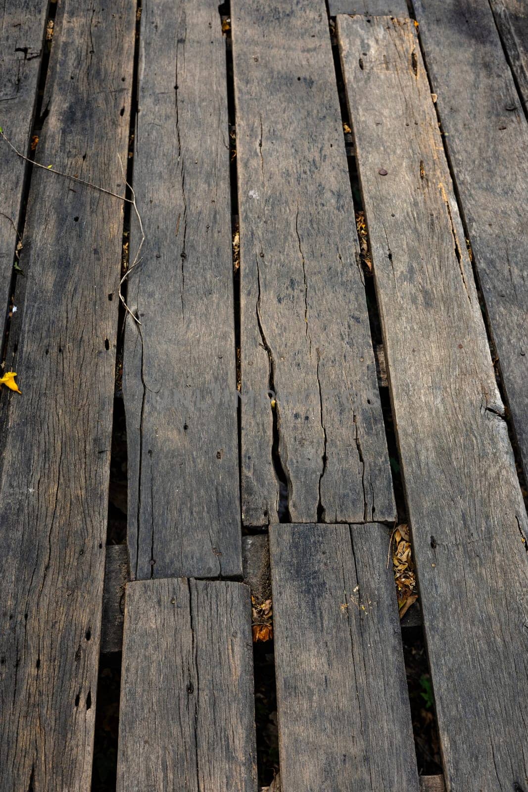 Close up of old abandoned rickety foot bridge. Old wood texture background coming from natural tree. The wooden panel has a beautiful dark pattern.