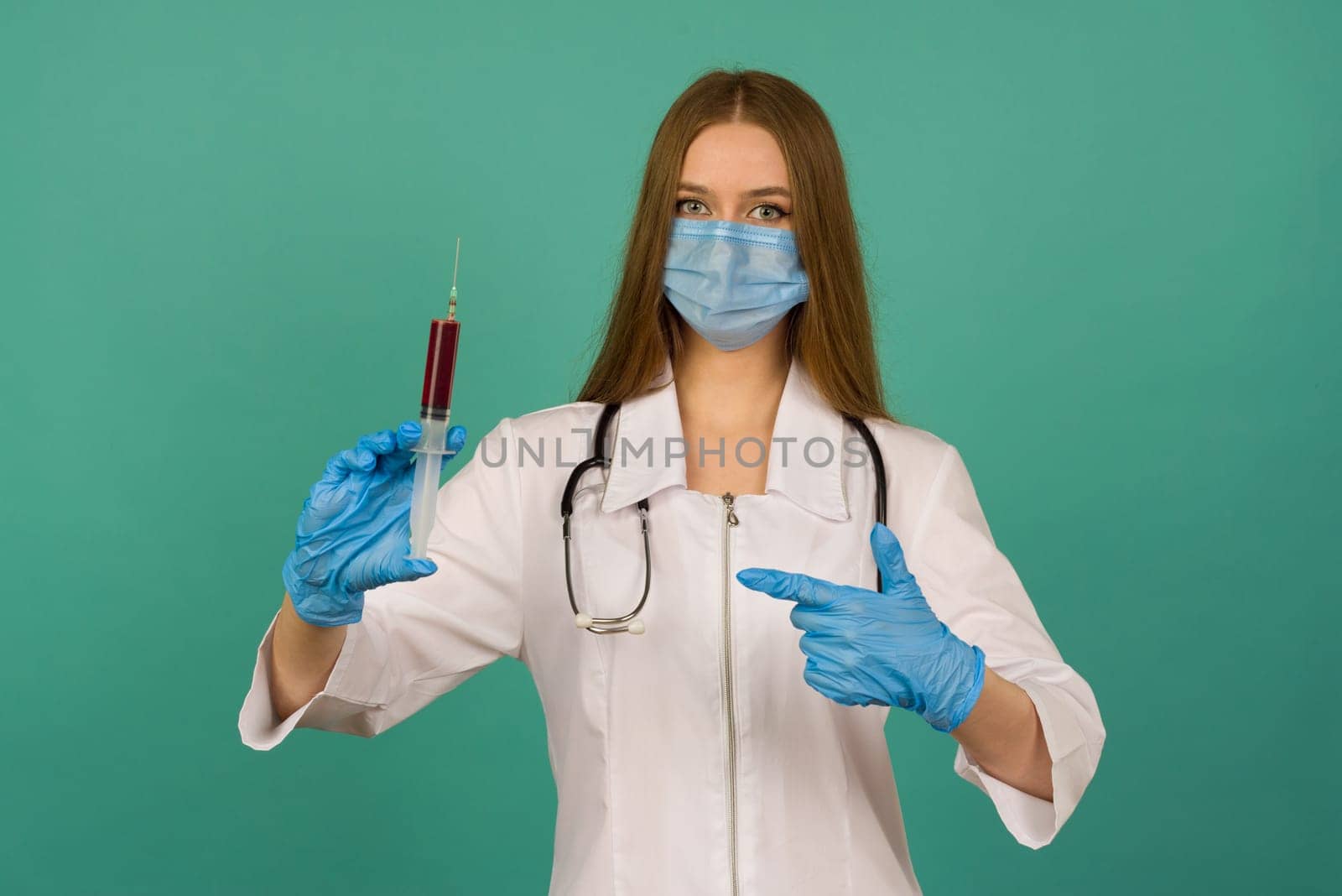 Covid19, coronavirus. Portrait of professional confident young caucasian doctor in medical mask and white coat, stethoscope over neck, with vaccine syringe in hand, fight disease by zartarn