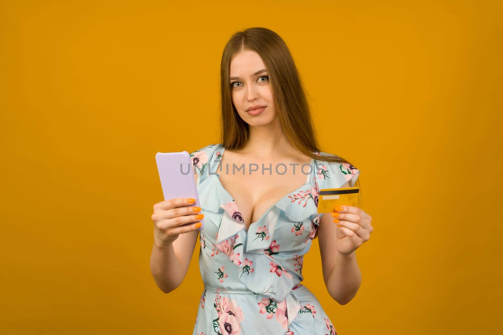 Lady buying online with a credit card and smart phone on yellow background by zartarn