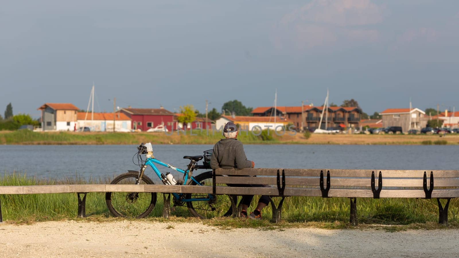 senior man sitting on a bench looking at the sea a sunny day