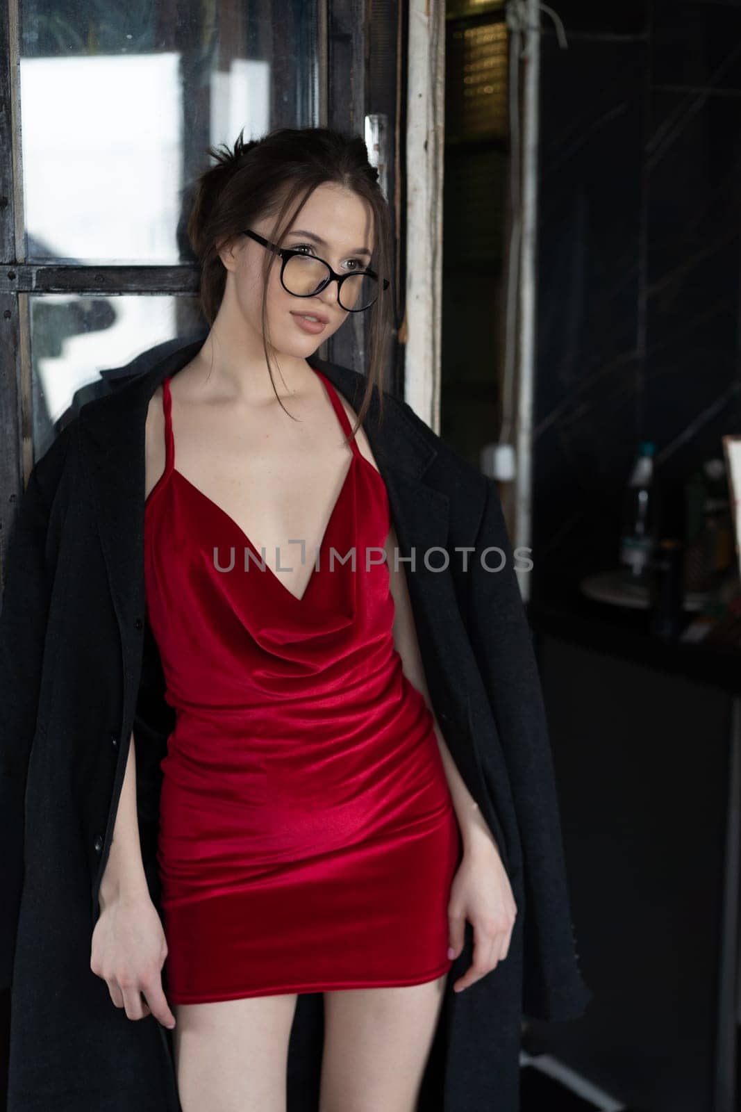 young beautiful woman posing in a red short dress in the studio