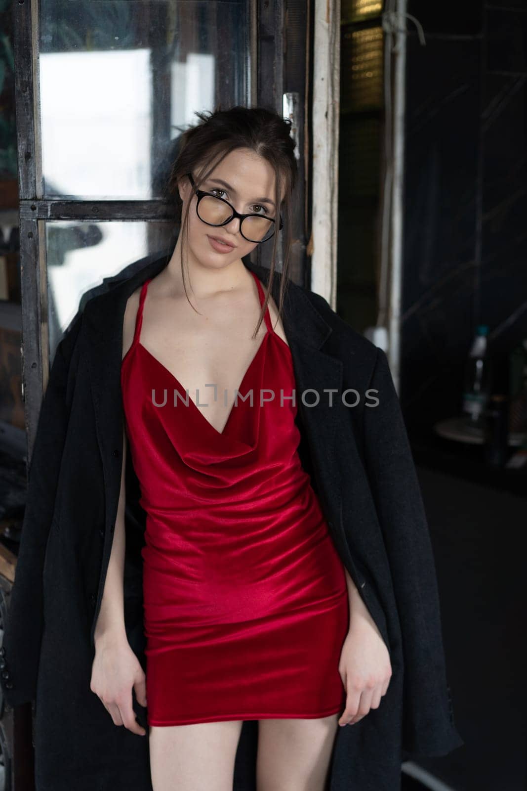 young beautiful woman posing in a red short dress in the studio