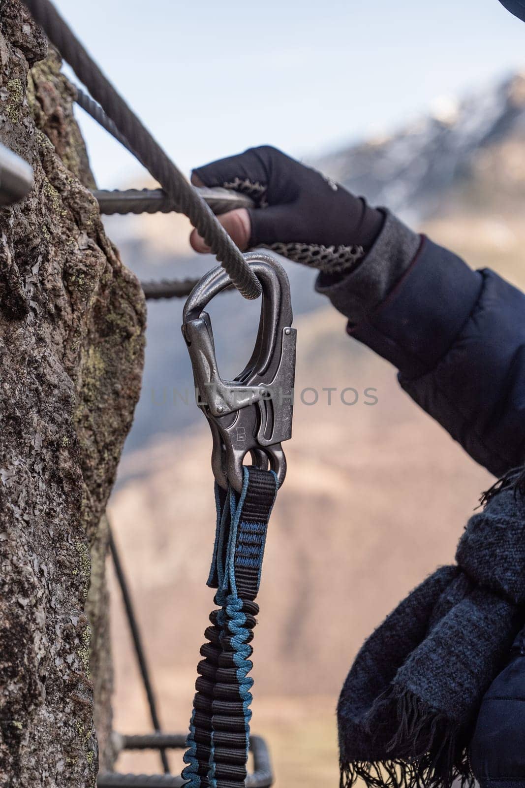 Climbing rope slides in a carabiner and mountain stream in the background by FreeProd