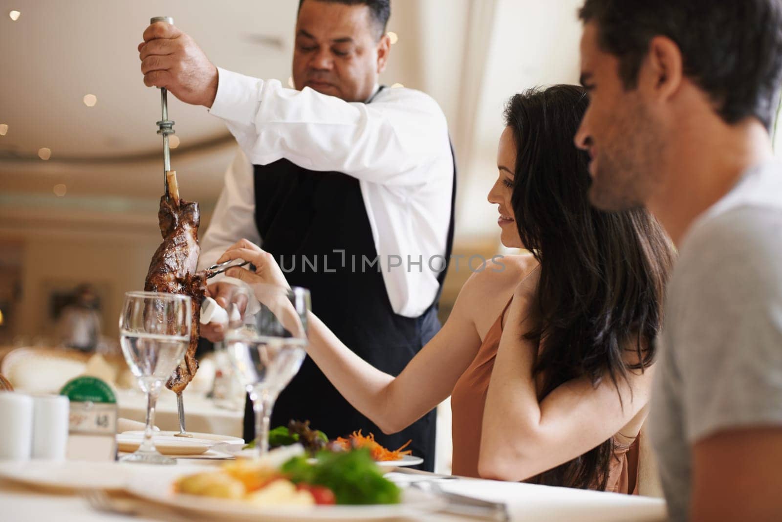 Couple, restaurant and date for dinner, service and love for celebration on holiday. Woman, man and fine dining with luxury, smile and romance for vacation or marriage anniversary with gourmet meal by YuriArcurs