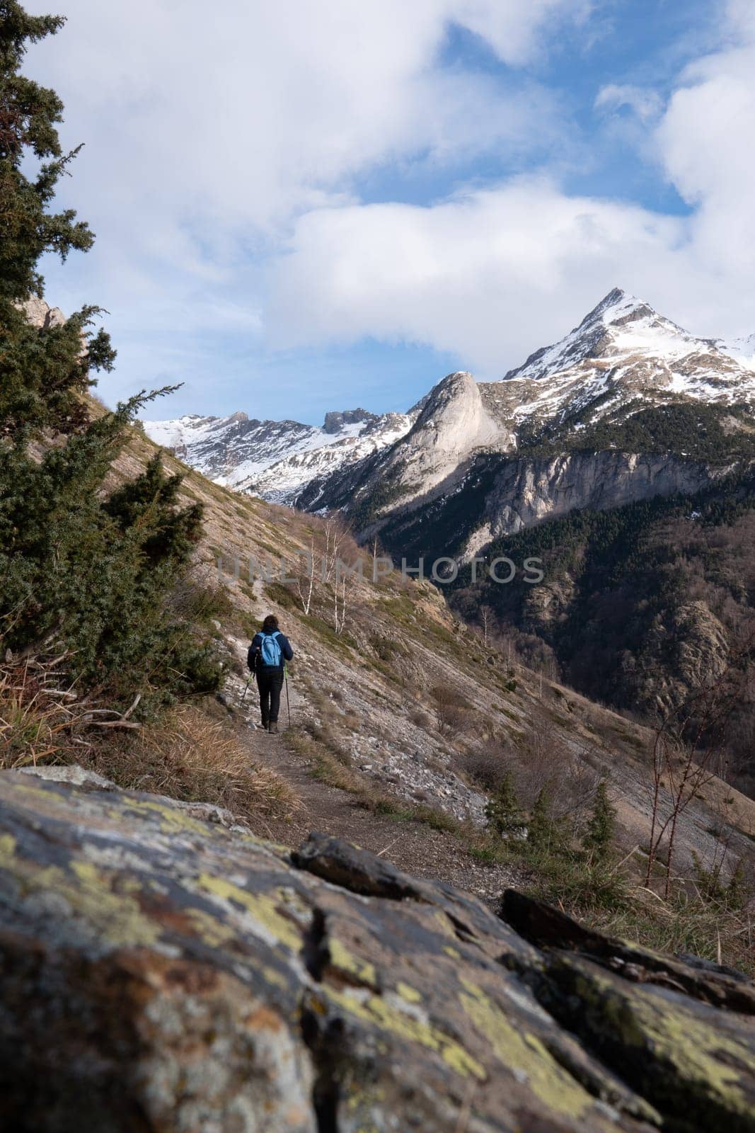 Hiker walking on the path in Pyrenees mountains near Gavarnie by FreeProd