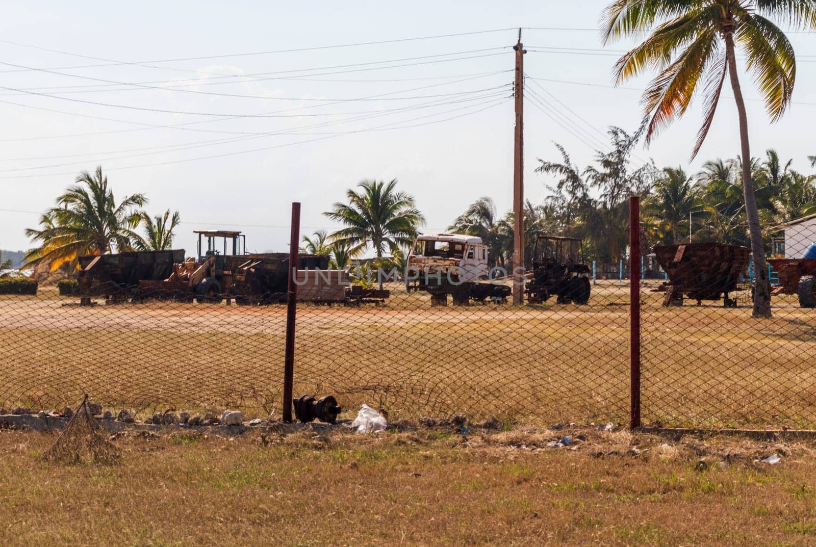 Shot of the rural village. Damaged gear, equipment and vehicles on the background