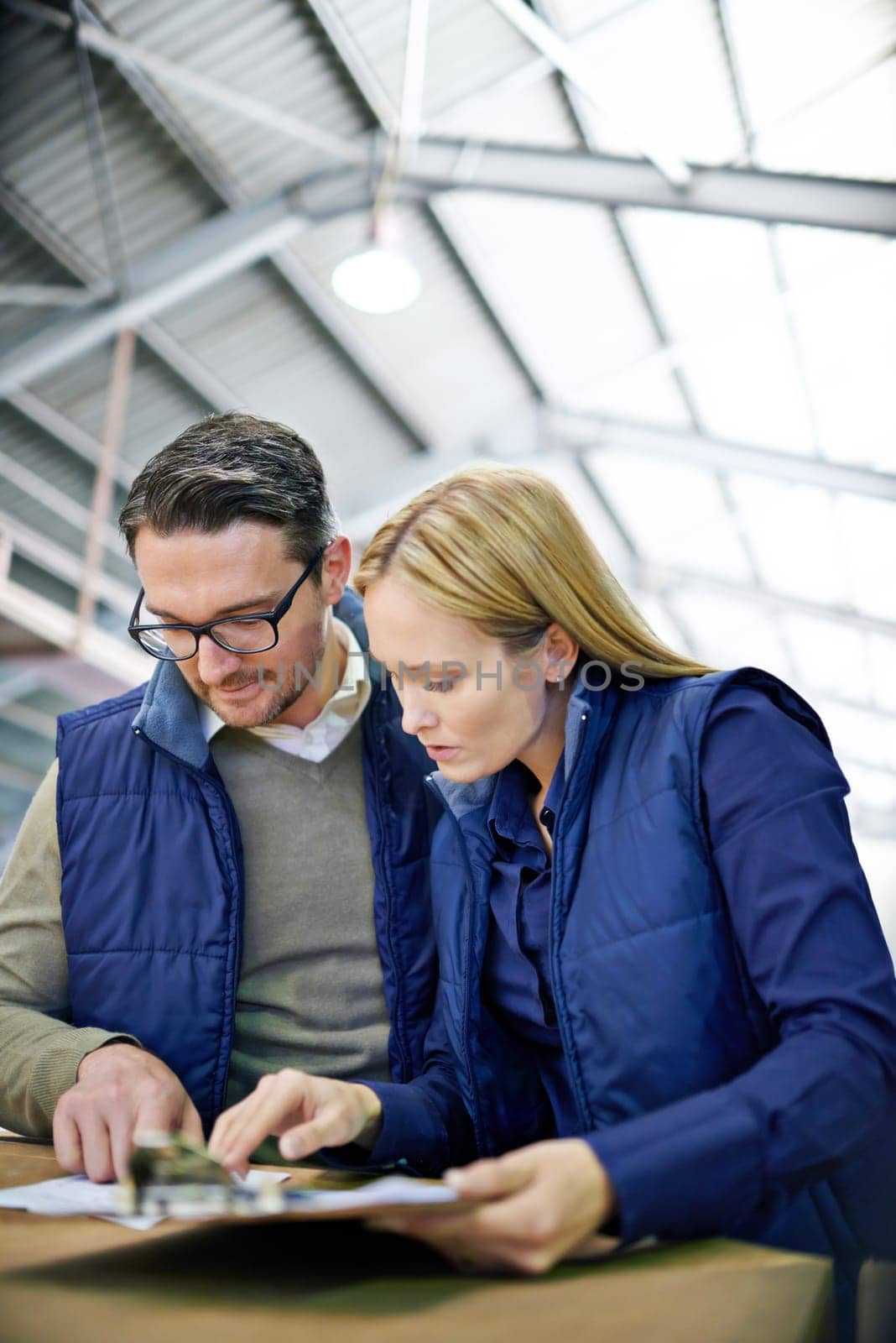 Business people, clipboard and checklist with inventory for storage control in supply chain at warehouse. Young coworkers, team or employees reading documents or paperwork for distribution at factory.