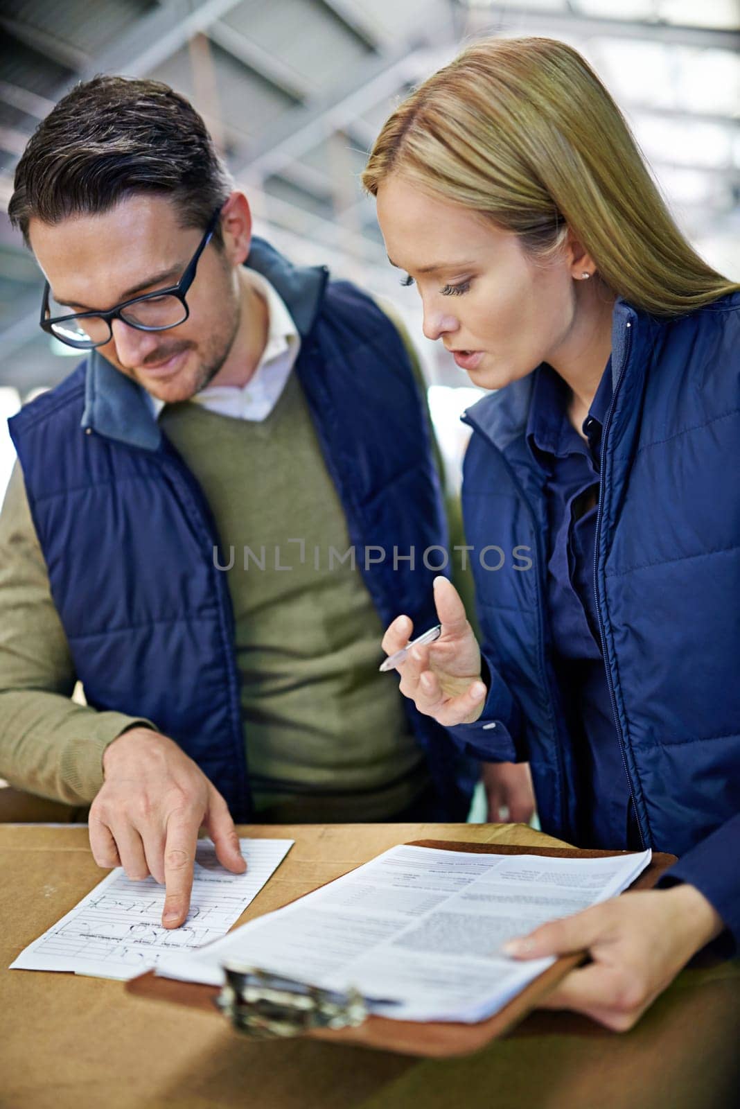 Business people, reading and checking inventory with storage in supply chain at warehouse. Logistic coworkers, team or employees looking at documents, paperwork or clipboard for distribution factory.