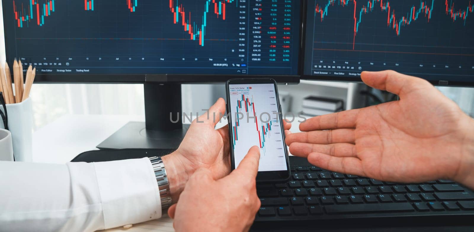 Cropped photo of exchange traders pointing lowest chart stage on dynamic graph with smartphone on panorama view, analyzing comparing with monitor and phone, discussing financial technology. Sellable.