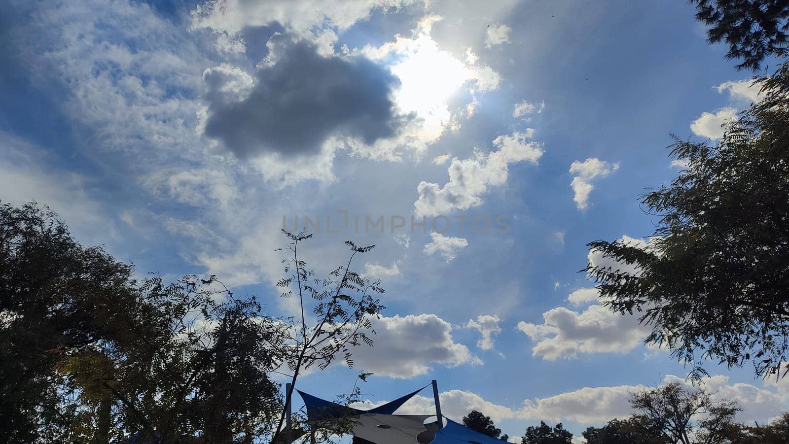 Blue gray light sky nature white clouds whether background, sun face . High quality photo