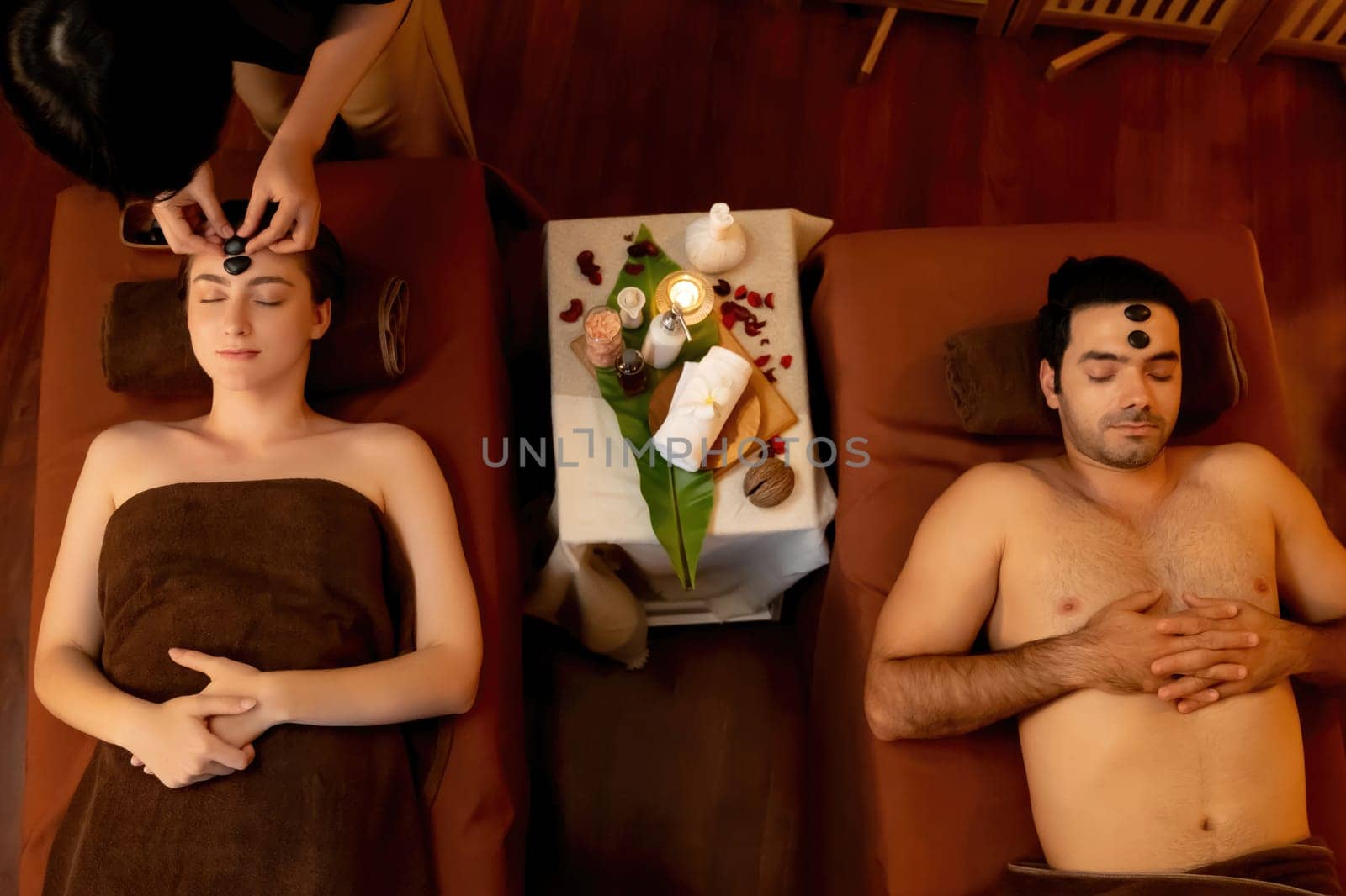 Caucasian couple enjoying relaxing anti-stress head massage with stone.Quiescent by biancoblue