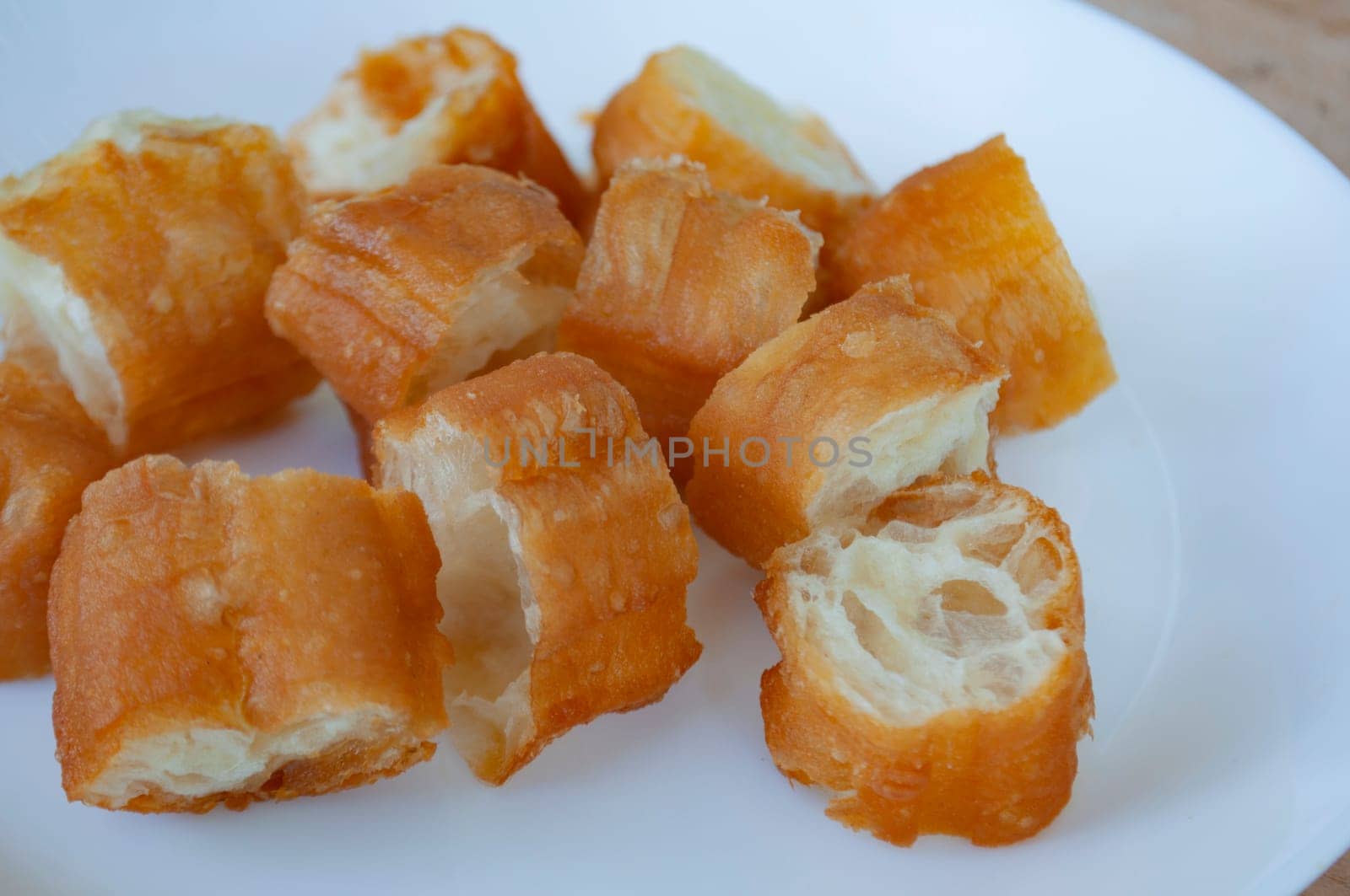 Close up view of cut cakoi or youtiao cake on white plate. Asian food concept