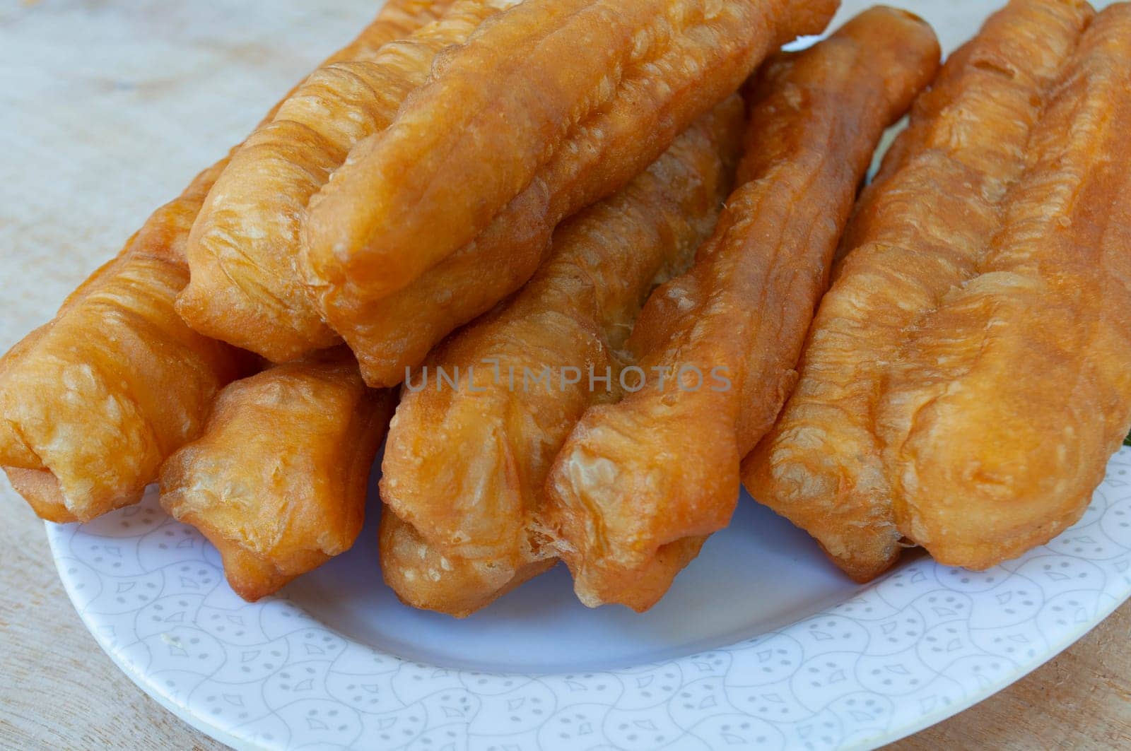 Close up of cakoi or youtiao cake on white plate. Asian food concept.