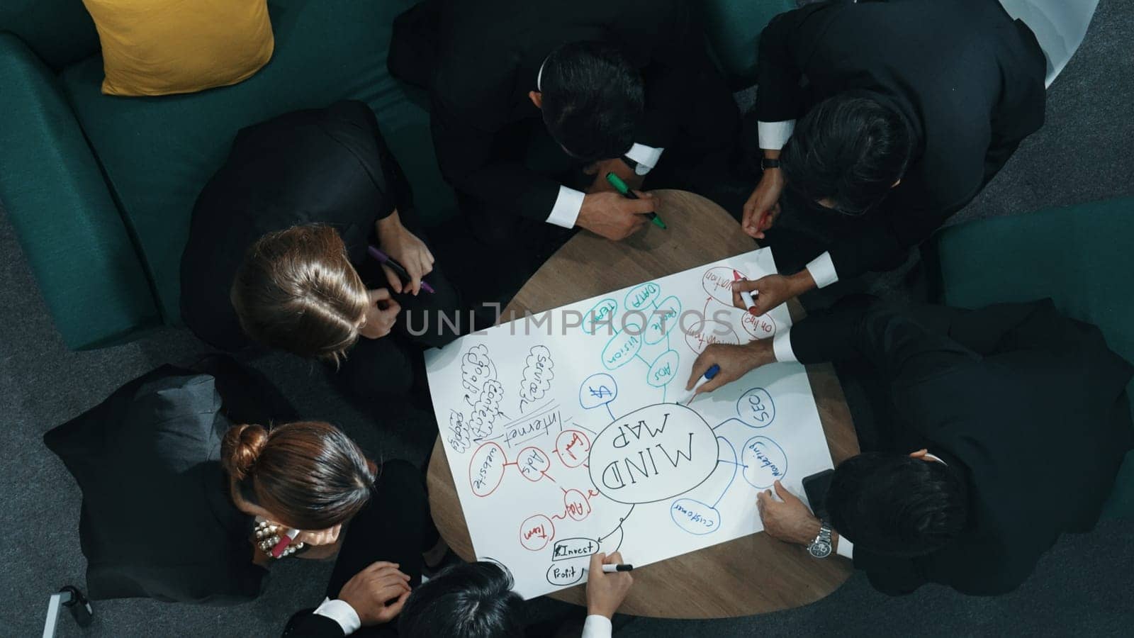 Top view of skilled diverse business people planning project by using mind map to brainstorm marketing idea. Smart start up team working together to draw mind map. Creative workplace. Directorate.