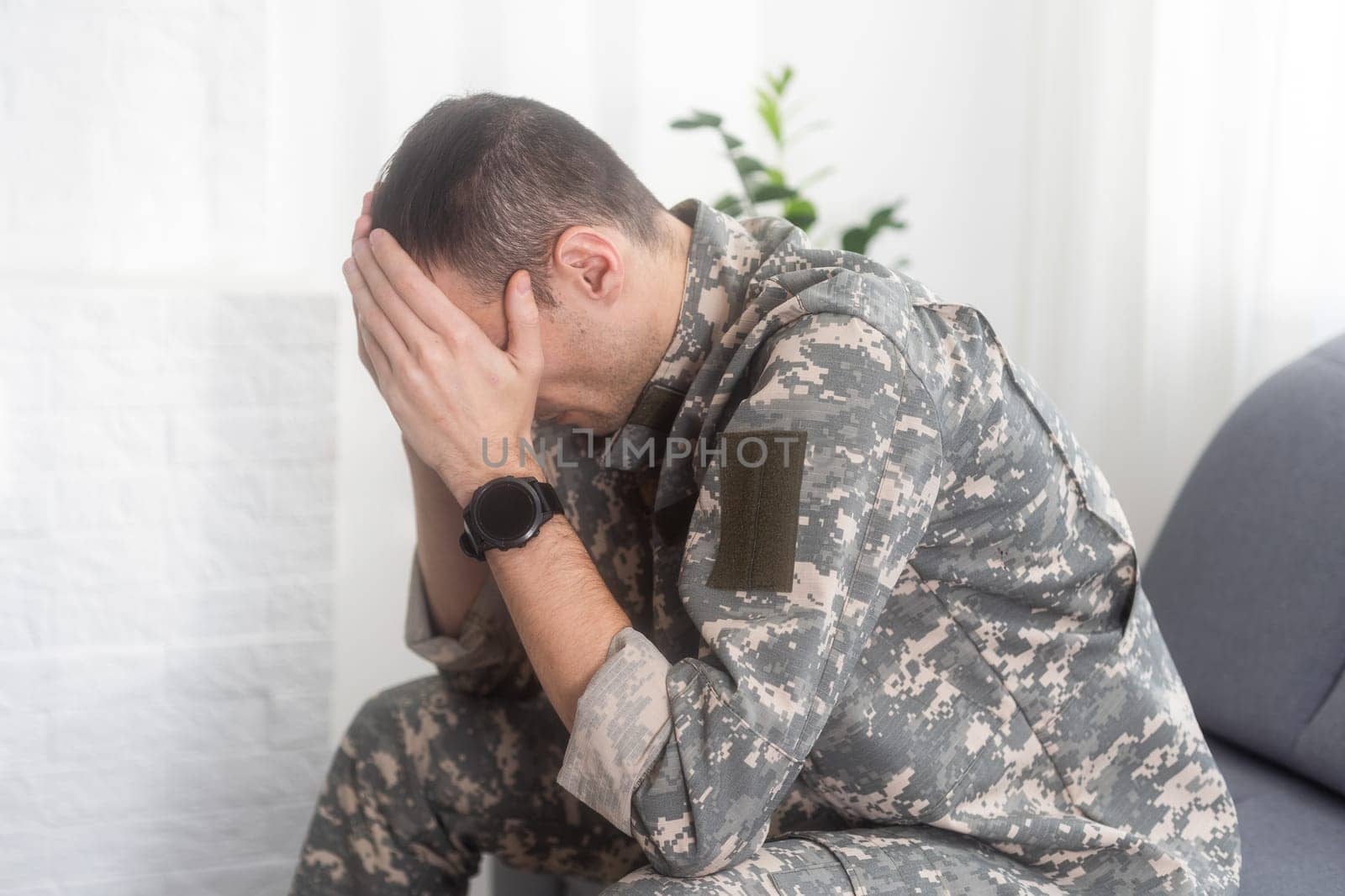 Nervous male military suffering depression, sitting alone at home, PTSD concept. High quality photo