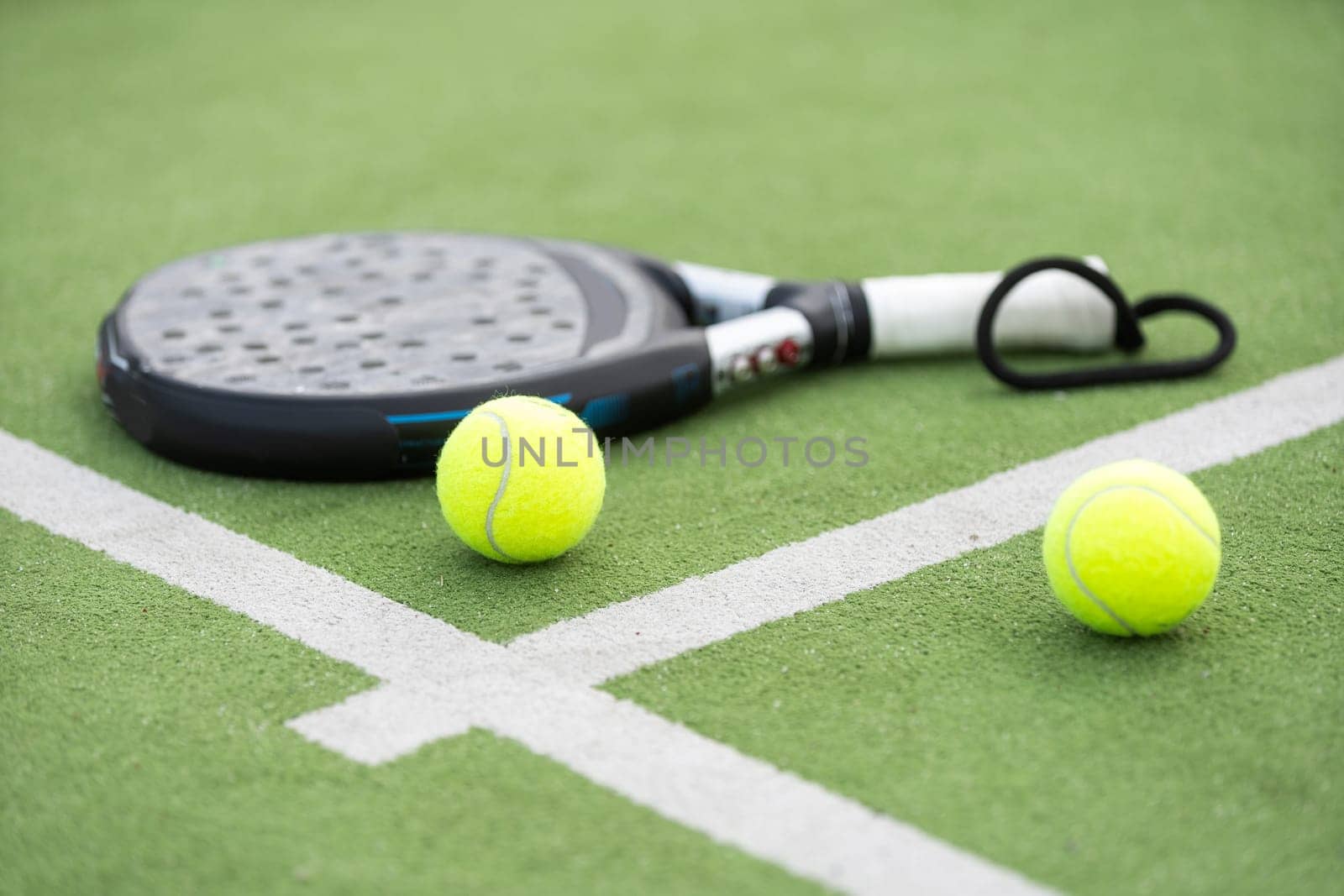 paddle tennis racket and balls on court . High quality photo